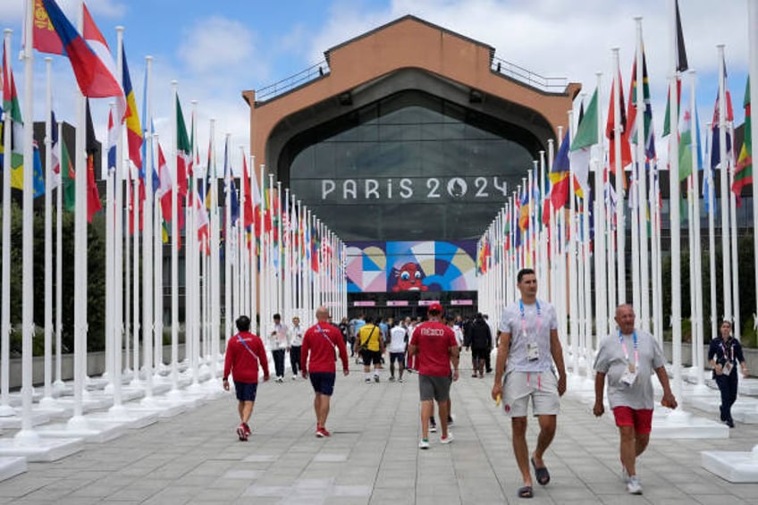 Participants of the Paris 2024 Olympics and Paralympics game walk in front of the cafeteria of the Olympic Village, in Saint-Denis, northern Paris,...