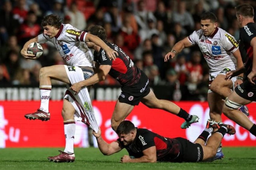 Bordeaux-Begles' French centre Pablo Uberti (L) is tackled as he tries to break the Toulou