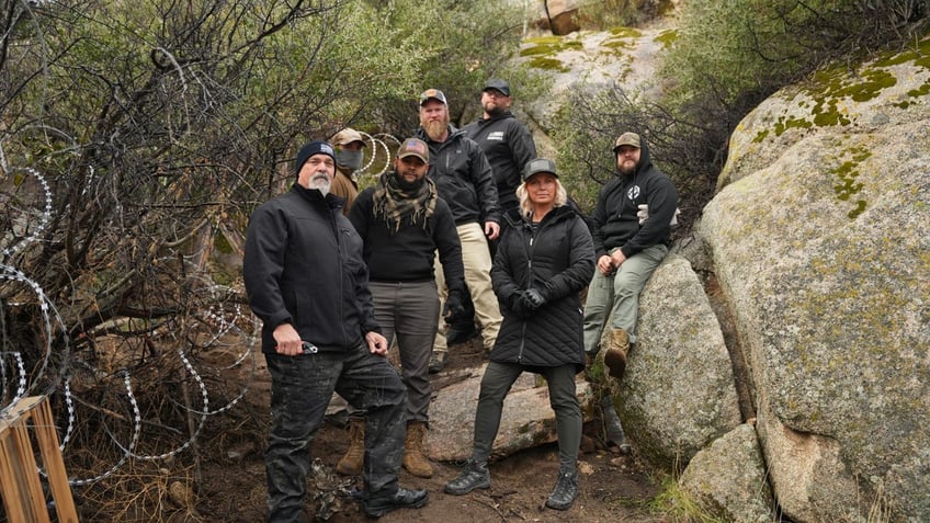 Border Vets members pose for photo by border wall