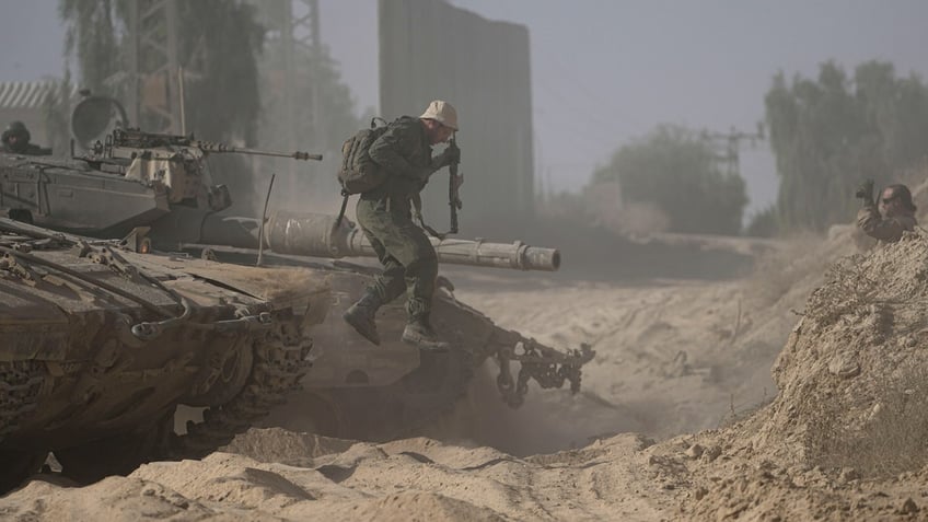 An Israeli soldier dismounts from his tank near the Israel-Gaza border in southern Israel.