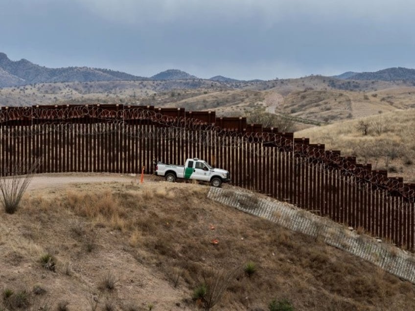 TOPSHOT - A Border Patrol officer sits inside his car as he guards the US/Mexico border fence, in Nogales, Arizona, on February 9, 2019. (Photo by Ariana Drehsler / AFP) (Photo credit should read ARIANA DREHSLER/AFP/Getty Images)