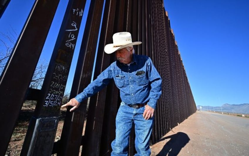 Cattle rancher John Ladd points to dates written on a lower section of the thirty-foot tal