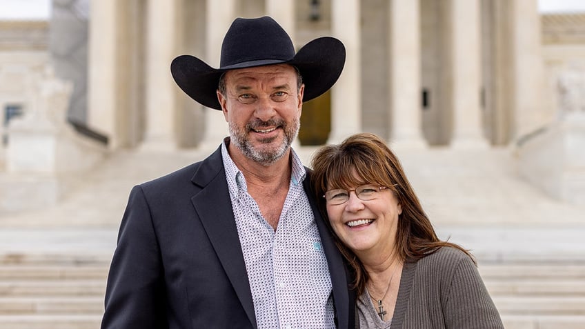 Richie DeVillier and his wife stand in front of Supreme Court