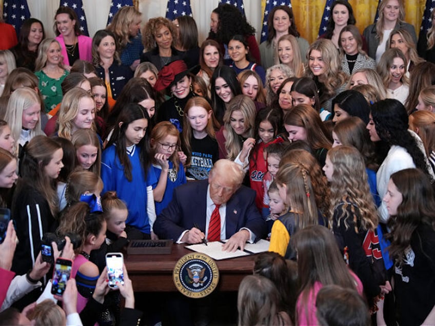 WASHINGTON, DC - FEBRUARY 05: U.S. President Donald Trump joined by women athletes signs t