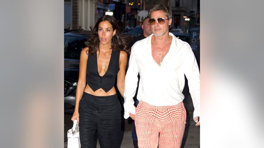 Brad Pitt, Ines de Ramon holding hands