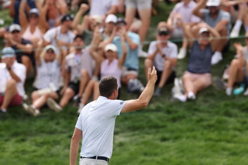 Leader Keegan Bradley acknowledges the crowd after making birdie on the 18th green during