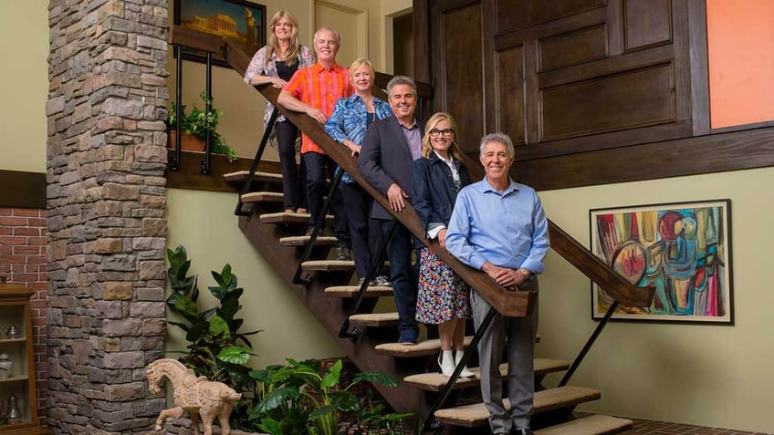 Brady Bunch stars Susan Olsen, Mike Lookinland, Eve Plumb, Christopher Knight, Maureen McCormick, and Barry Williams posing on the Brady Bunch Stairs