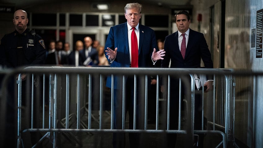 Former US President Donald Trump, center, speaks to members of the media at Manhattan criminal court