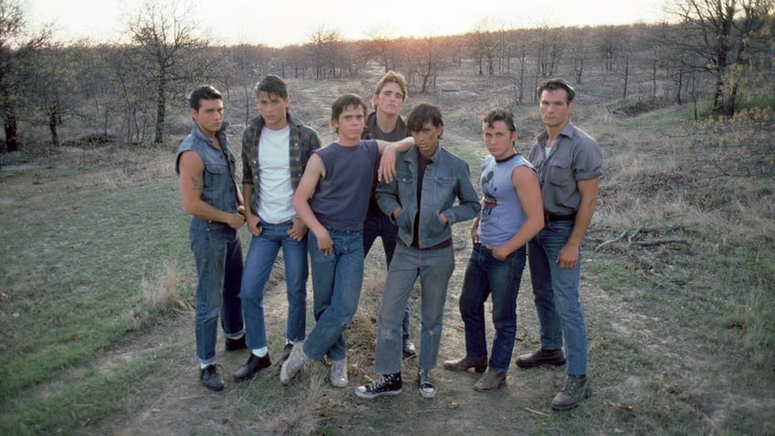 Tom Cruise, Rob Lowe, Thomas C. Howell, Matt Dillon, Ralph Macchio, Emilio Estevez and Patrick Swayze on the set of The Outsiders, directed by Francis Ford Coppola. 