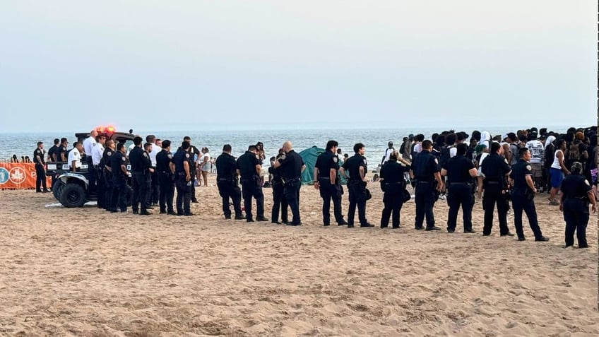 Police form a barricade after brawls broke out at Coney Island Beach on Monday.