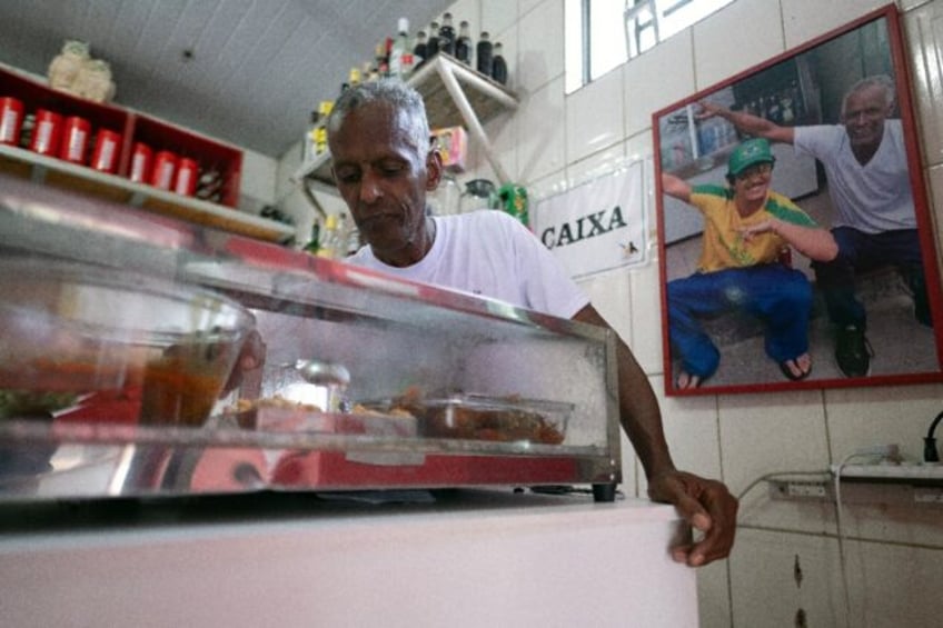 Ronaldo Teixeira, owner of Lacador, is pictured at the bar next to a photo of him with sin