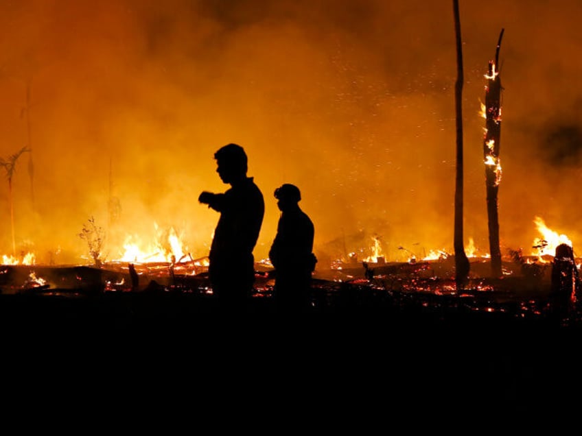 Firefighters work to put out a blaze in the Amazon forest during a drought and high temper