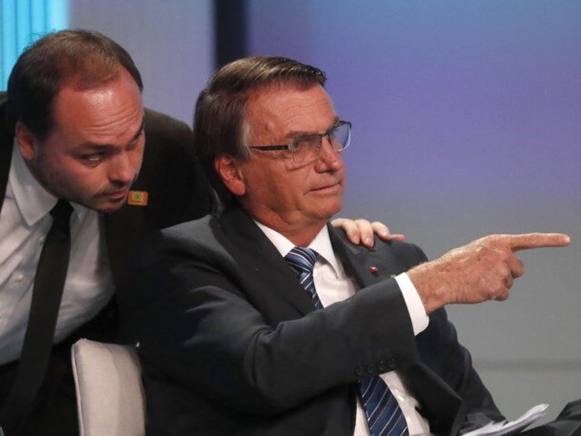 Carlos Bolsonaro, son of Brazil's President Jair Bolsonaro, who is running for re-election, whispers in his father's ear during his arrival at the presidential debate in Rio de Janeiro, Brazil, Sept. 29, 2022. Brazil's federal police carried out a search warrant Jan. 29, 2024 for Carlos Bolsonaro, a Rio de …