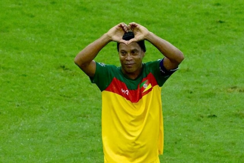 Brazilian former soccer star Ronaldinho reacts after scoring during a charity football mat