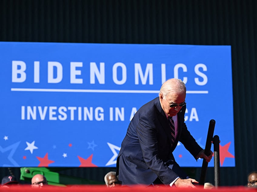 TOPSHOT - US President Joe Biden trips on the steps as he arrives on stage to speak about