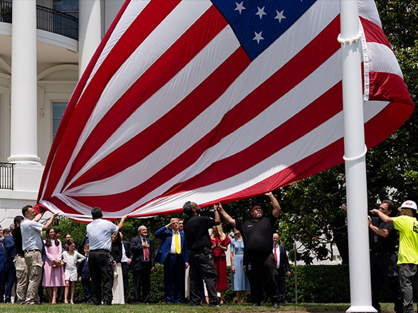 President Donald Trump watches as the flag is raised on the newly installed flagpole on th
