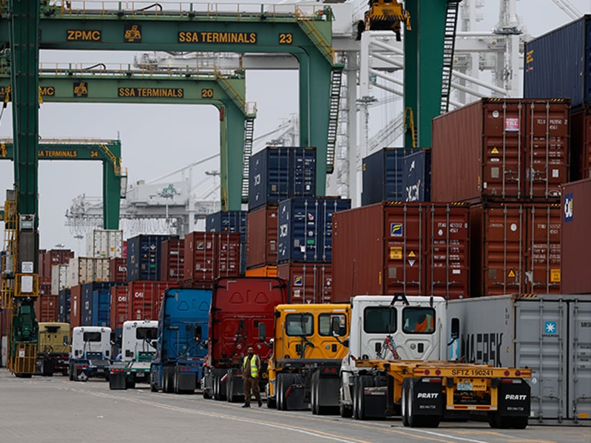 OAKLAND, CALIFORNIA - APRIL 18: Trucks line up to pick up shipping containers from a ship
