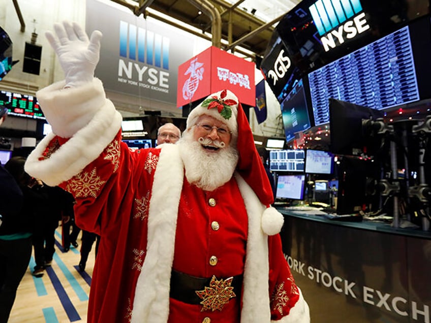 A man in a Santa Claus costume gestures on the floor at the closing bell of the Dow Industrial Average at the New York Stock Exchange on December 5, 2019 in New York. - Wall Street stocks finished slightly higher following a choppy session that avoided the big swings from …