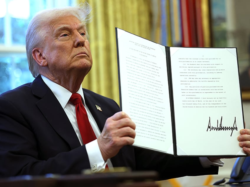 WASHINGTON, DC - MARCH 26: U.S. President Donald Trump displays a signed an executive orde