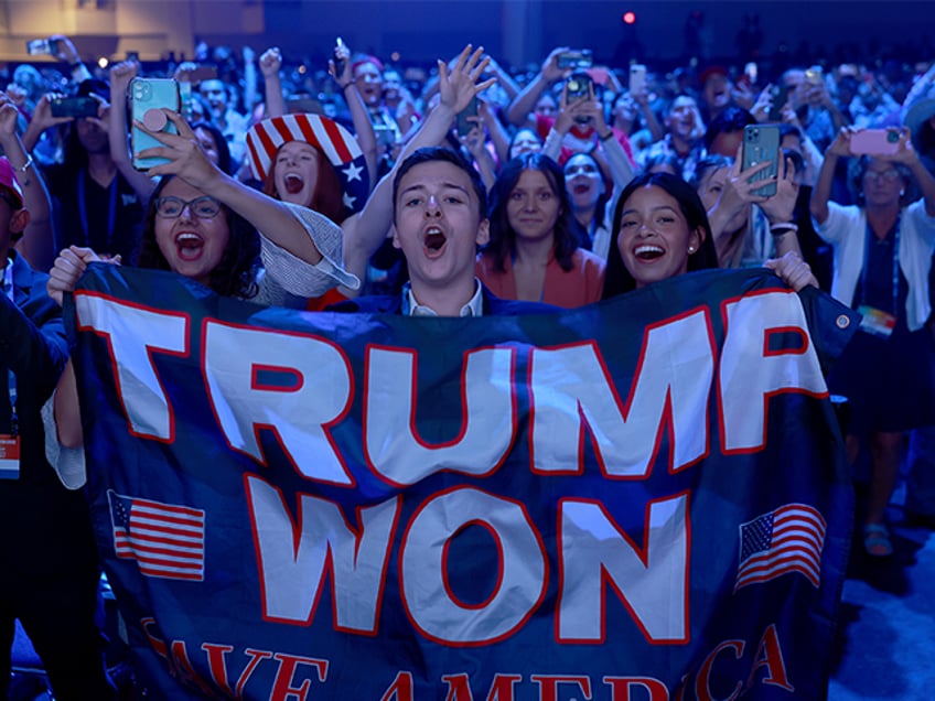 People cheer as former President Donald Trump arrives on stage during the Turning Point US