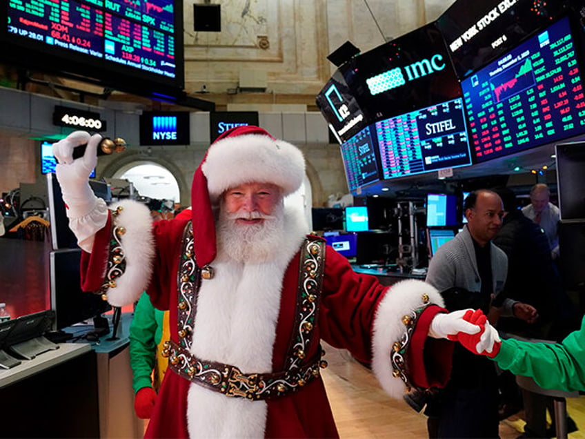 A man in a Santa Claus costume gestures on the floor at the closing bell of the Dow Industrial Average at the New York Stock Exchange on December 5, 2019 in New York. - Wall Street stocks finished slightly higher following a choppy session that avoided the big swings from …