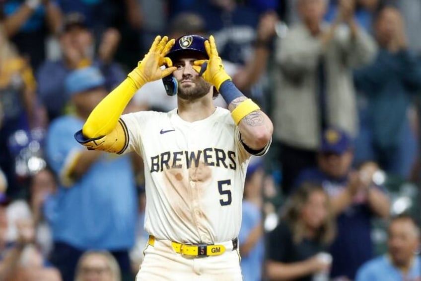 Garrett Mitchell of the Milwaukee Brewers reacts after hitting a run scoring triple in a g