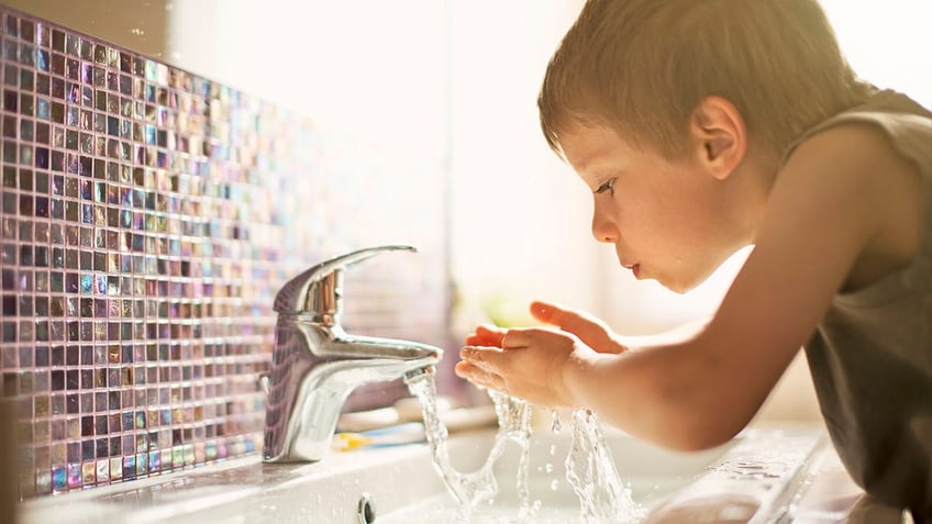 Little boy drinking tap water