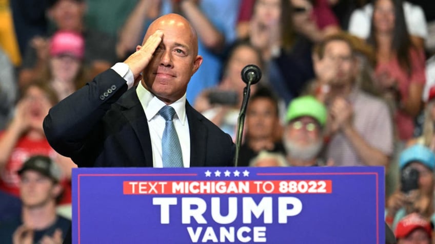 Brian Mast at Trump rally saluting behind lectern