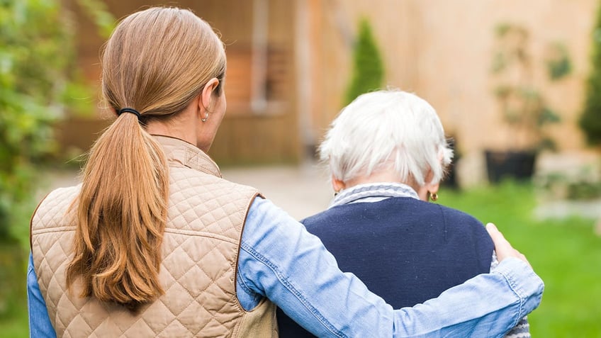 A woman caring for an elderly person