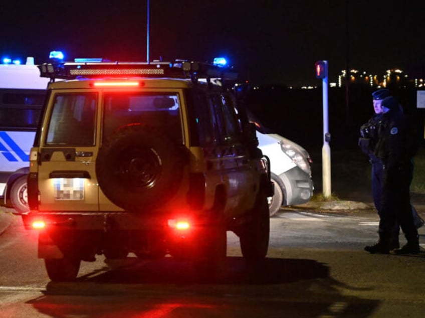 Police cordon off a migrant camp on a road between Mardyck and Loon Beach where two securi