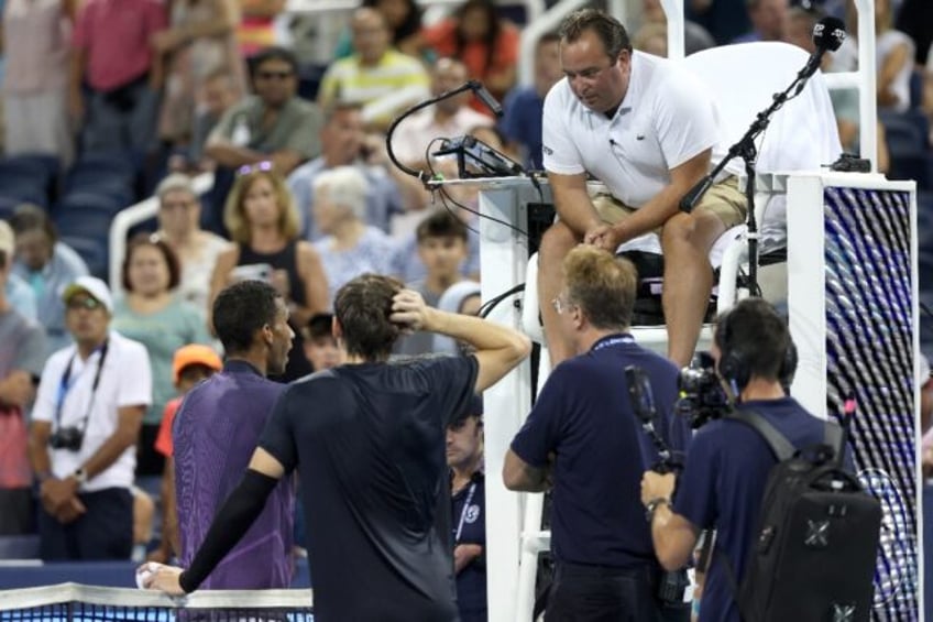 Chair umpire Greg Allensworth explains a controversial match-ending point to Canada's Feli