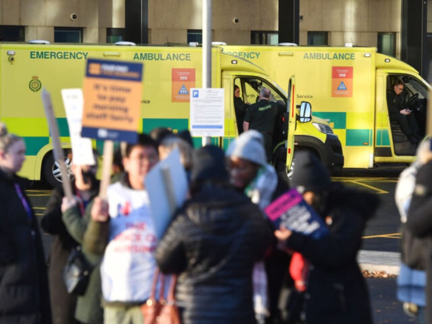 Ambulance drivers outside the Emergency Department beyond demonstrators on a picket line d