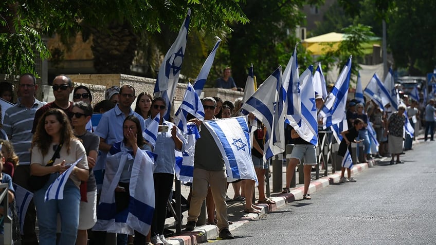 Mourners carrying Israel flags