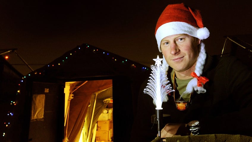 Prince Harry wearing a santa hat and white pigtails