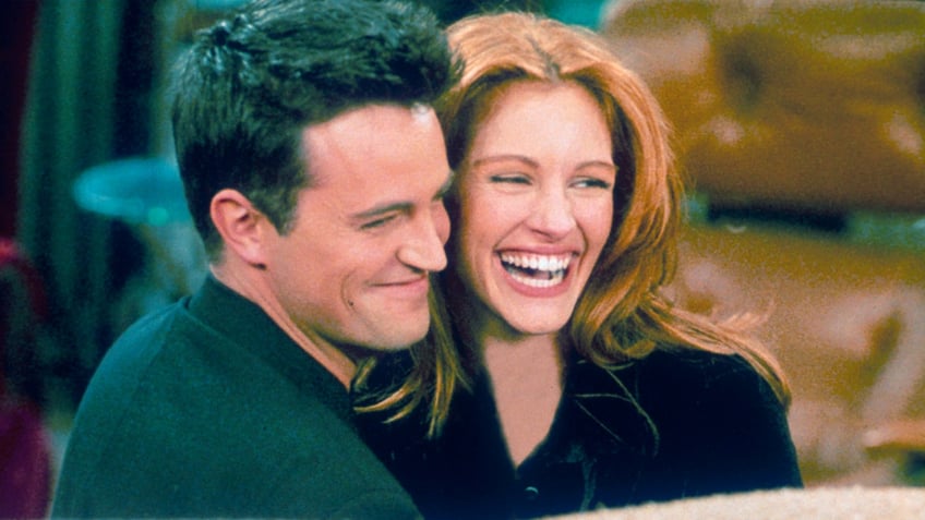 Matthew Perry as Chandler on the set of "Friends" hugs actress Julia Roberts