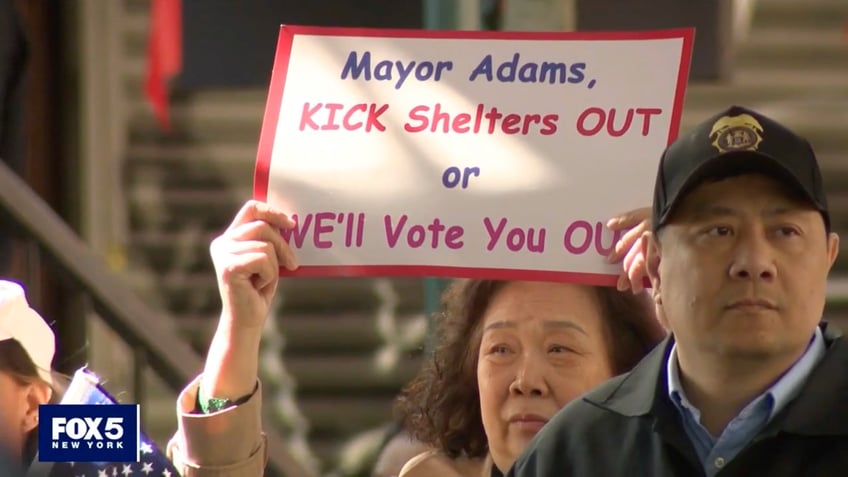 Sign saying 'Mayor Adams, kick shelters out or we'll vote you out'