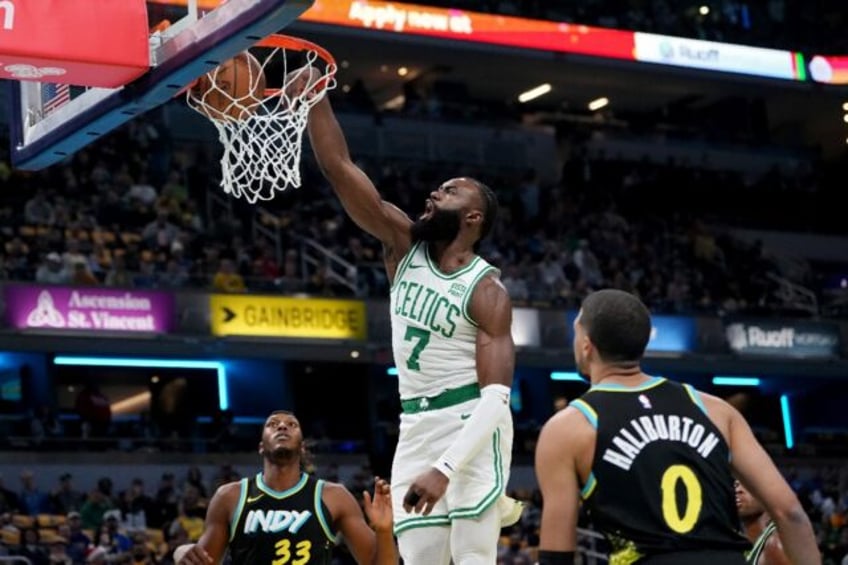 Boston's Jaylen Brown, dunking over Indiana's Myles Turner, left, and Tyrese Haliburton, r