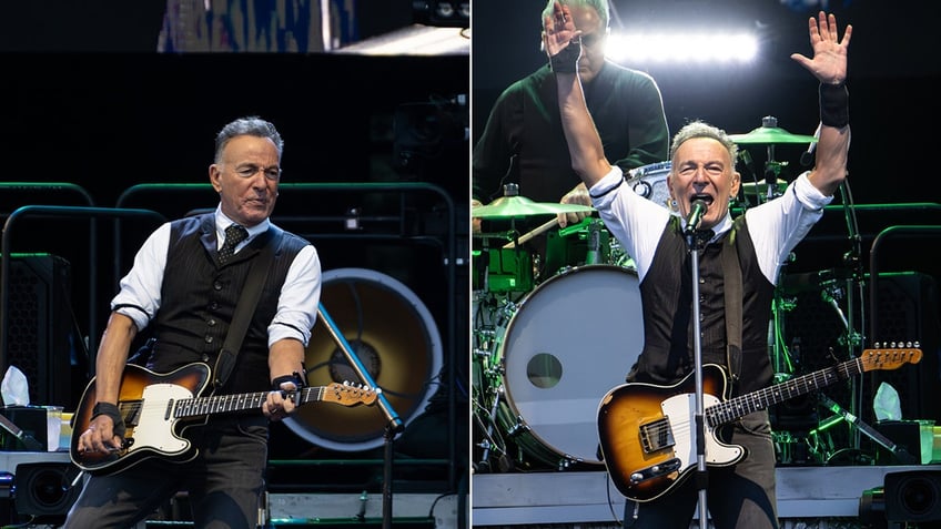 Bruce Springsteen in a black vest plays on stage with his guitar split Bruce Springsteen puts both his hands in the air on stage