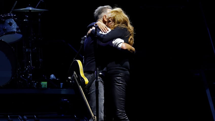 Singer Bruce Springsteen hugs wife Patti Scialfa during a concert.