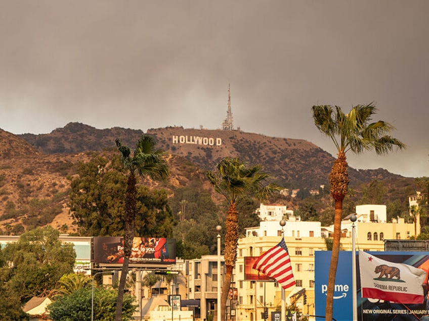 HOLLYWOOD, CA - JANUARY 08: The Hollywood Sign is seen with smoke from multiple wildfires