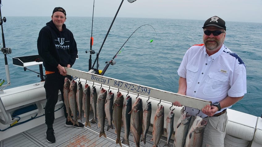 Buck McNeely shows off fish caught from a boat