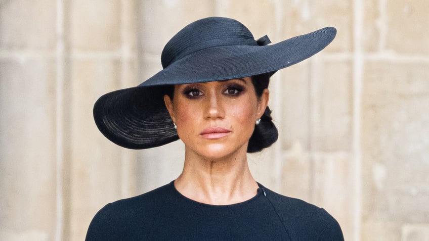 Meghan Markle wears a black dress and a black hat at Queen Elizabeths funeral.