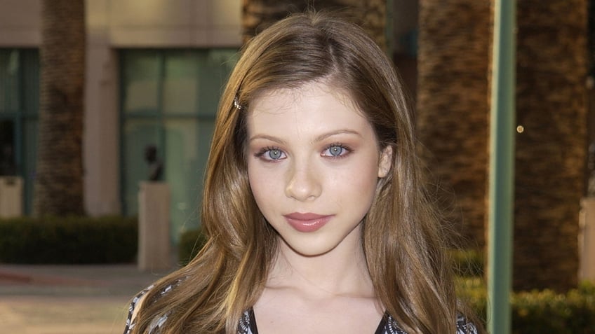 Actress Michelle Trachtenberg wears floral blouse.