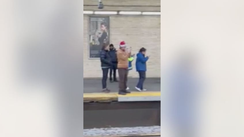 People watch bull on train tracks