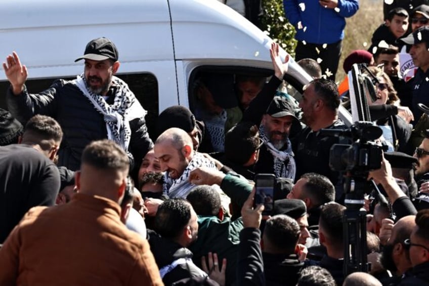 A cheering crowd hoisted freed Palestinian prisoners onto their shoulders after they arriv