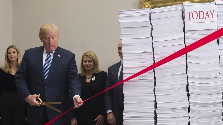 President Trump next to stacks of paper