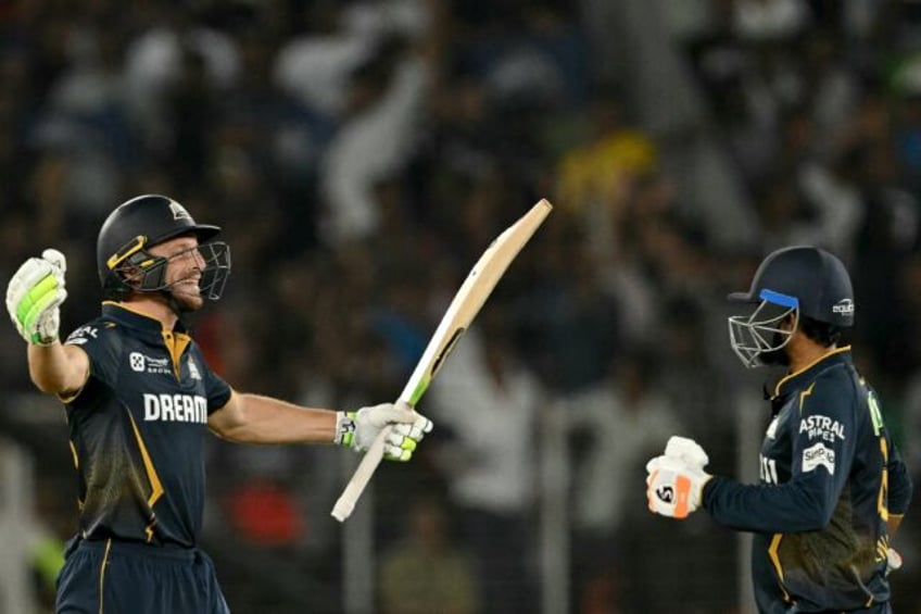 Jos Buttler (L) and Rahul Tewatia celebrate a win over the Delhi Capitals that took Gujara