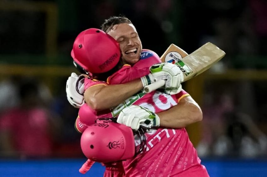 Rajasthan Royals' Jos Buttler (R) secured victory by hitting a six to bring up his hundred