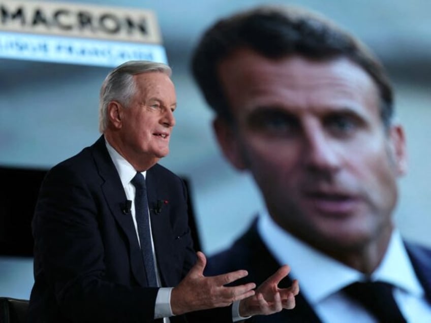 France's Prime Minister Michel Barnier speaks next to a screen displaying a picture of Fre