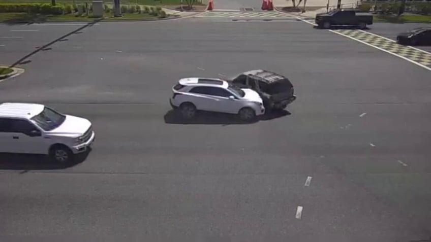 Group of people help flip over car on intersection